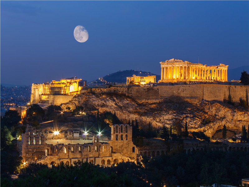 Parthenon and Herodium construction in Acropolis Hill in Athens, Greece shot in blue hour with moon in the sky.jpg