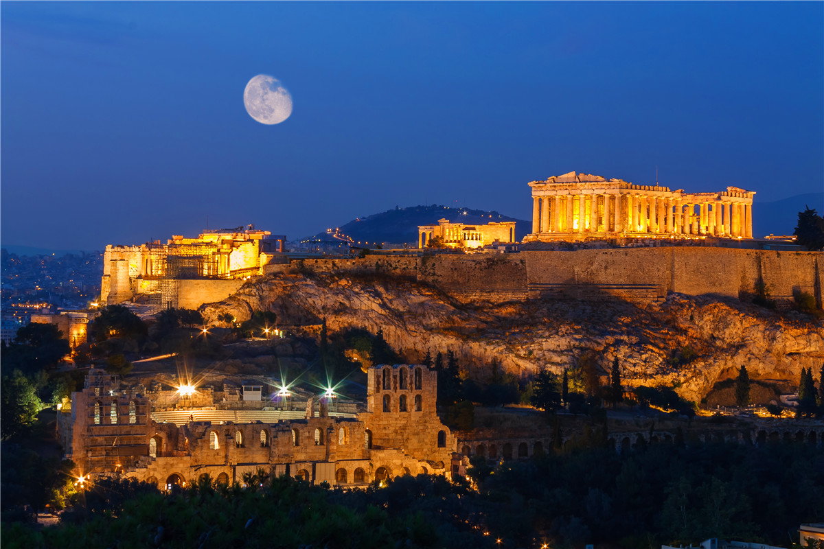 Parthenon and Herodium construction in Acropolis Hill in Athens, Greece shot in blue hour with moon in the sky.jpg